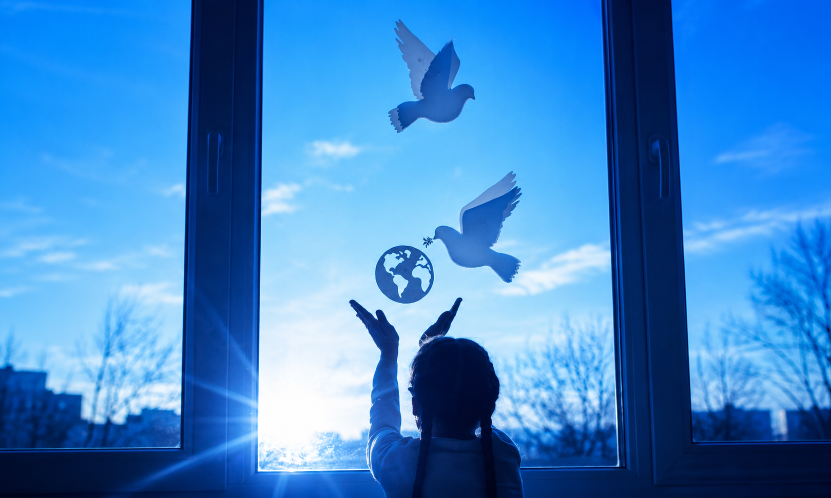 Child raising their hands toward doves and a globe on a window, symbolising peace, hope and the wisdom of Ecclesiastes.